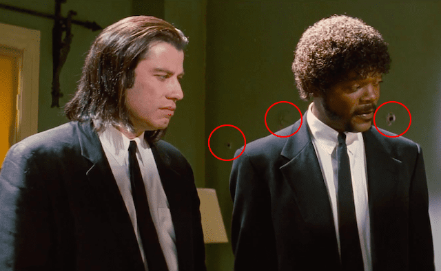 Image of a scene from Pulp Fiction with a continuity error, where bullet holes are circled in red behind John Travolta and Morgan Freeman's characters. These holes appear before the shooting scene takes place.