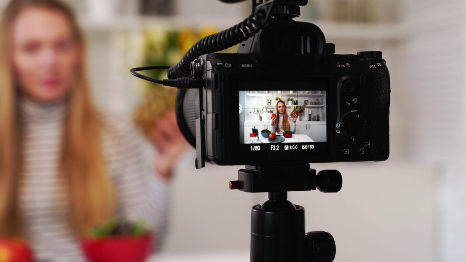 3 reasons why your video engagement is low (and how to fix it) - image of a camera on a tripod showing a woman in the viewfinder