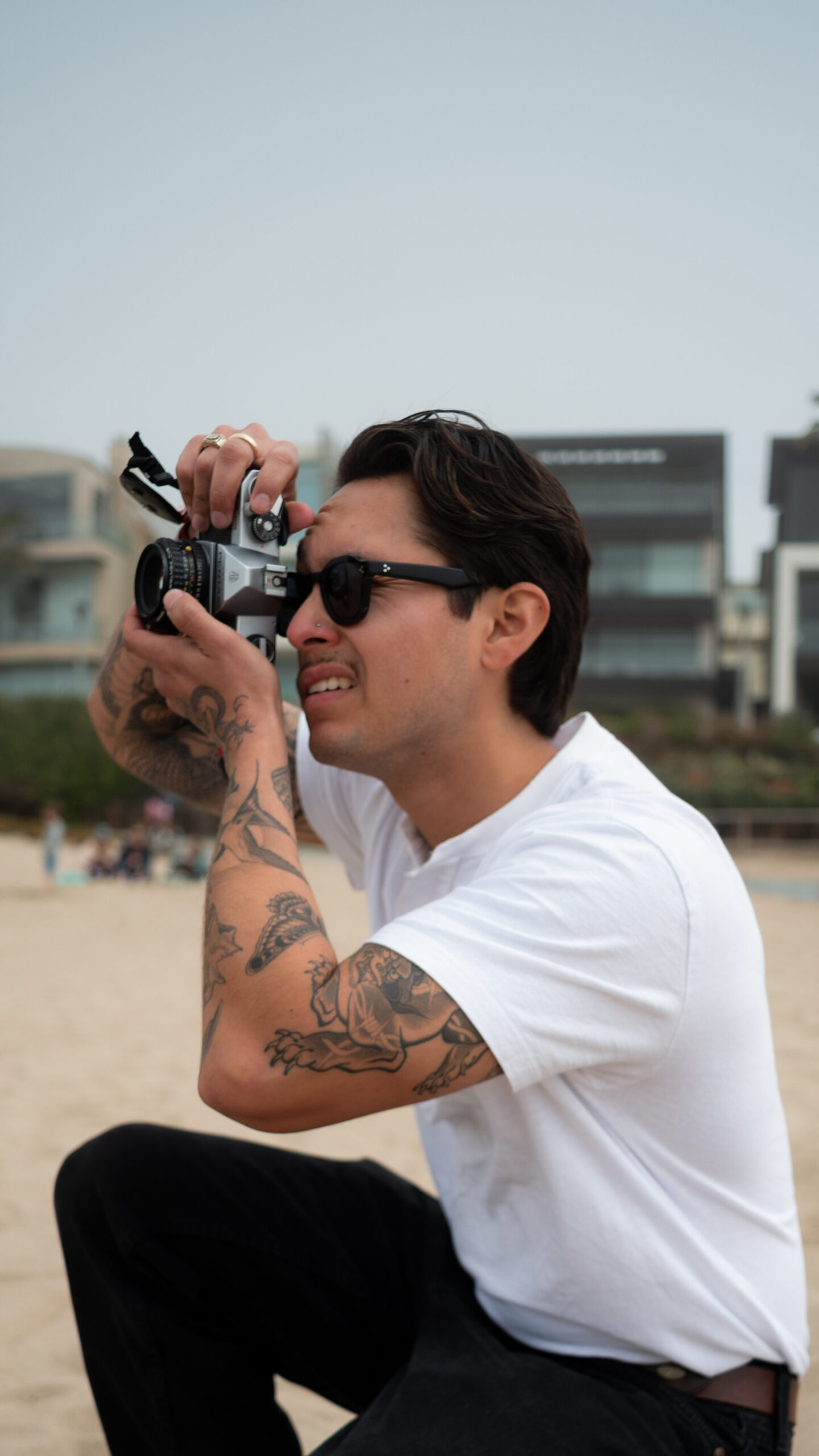 Photo of Dominic Lorenzo filming with a handheld camera for his Re: Stock collection.