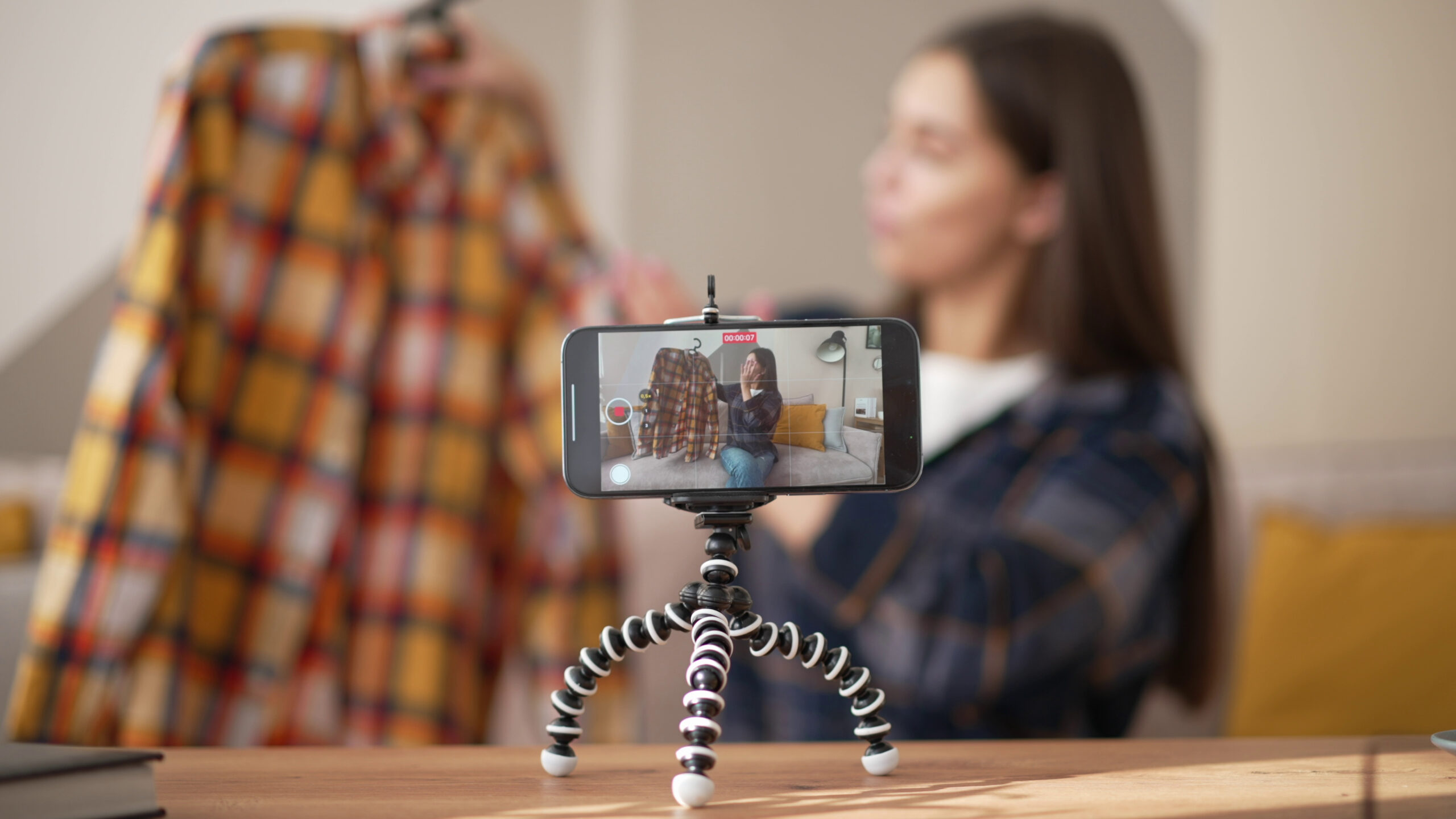 Still Image of Woman Blogger Shooting Video On Smartphone Talking About Shirt Fashion Vlogger Influencer Reviewing Casual Shirt For Vlog Girl Stylist Filming Vlog Episode For Her Channel